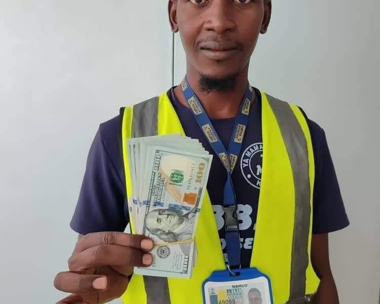 Auwal Ahmed Dankode, Airline cleaner, displays $10,000 found in a plane