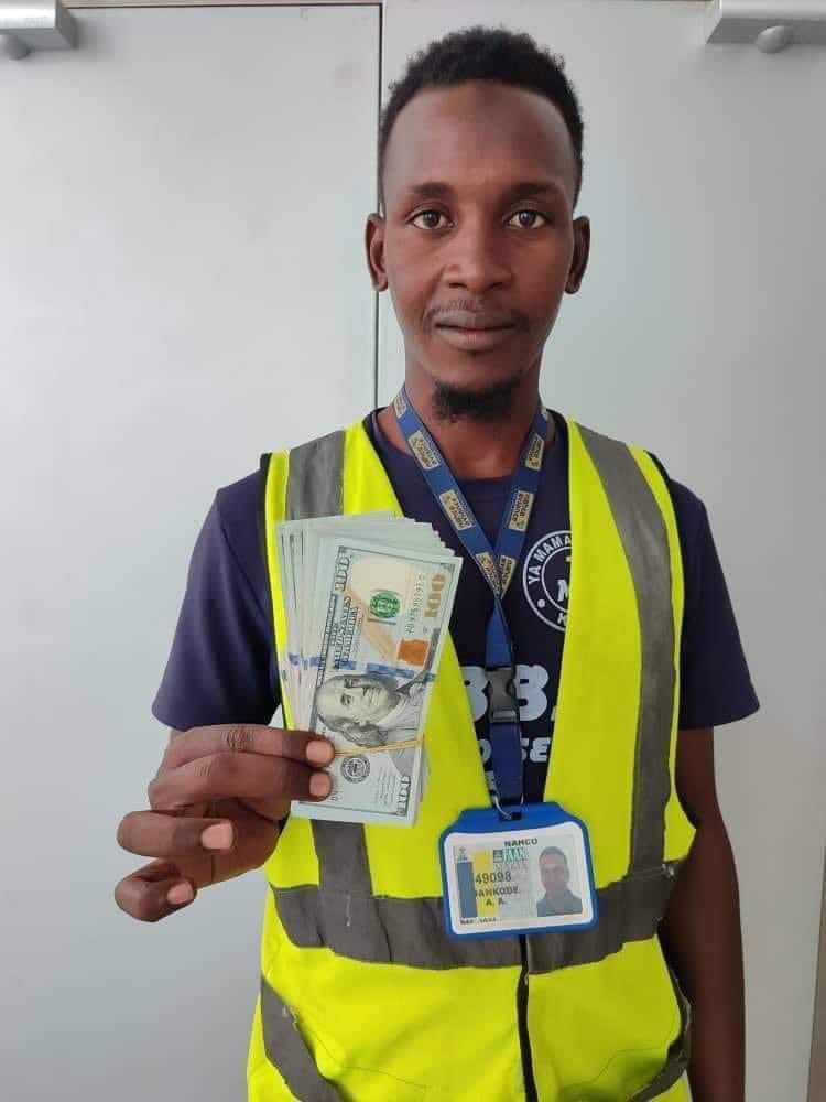 Auwal Ahmed Dankode, Airline cleaner, displays $10,000 found in a plane